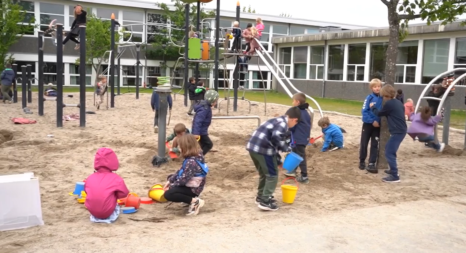 Børn der leger i sandet på en legeplads