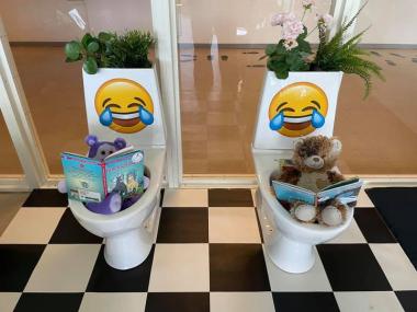 to bamser der sidder og læser i hvert deres toilet