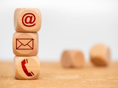 tre stablede terninger med hhv snabel-a, kuvert og telefonrør på siden